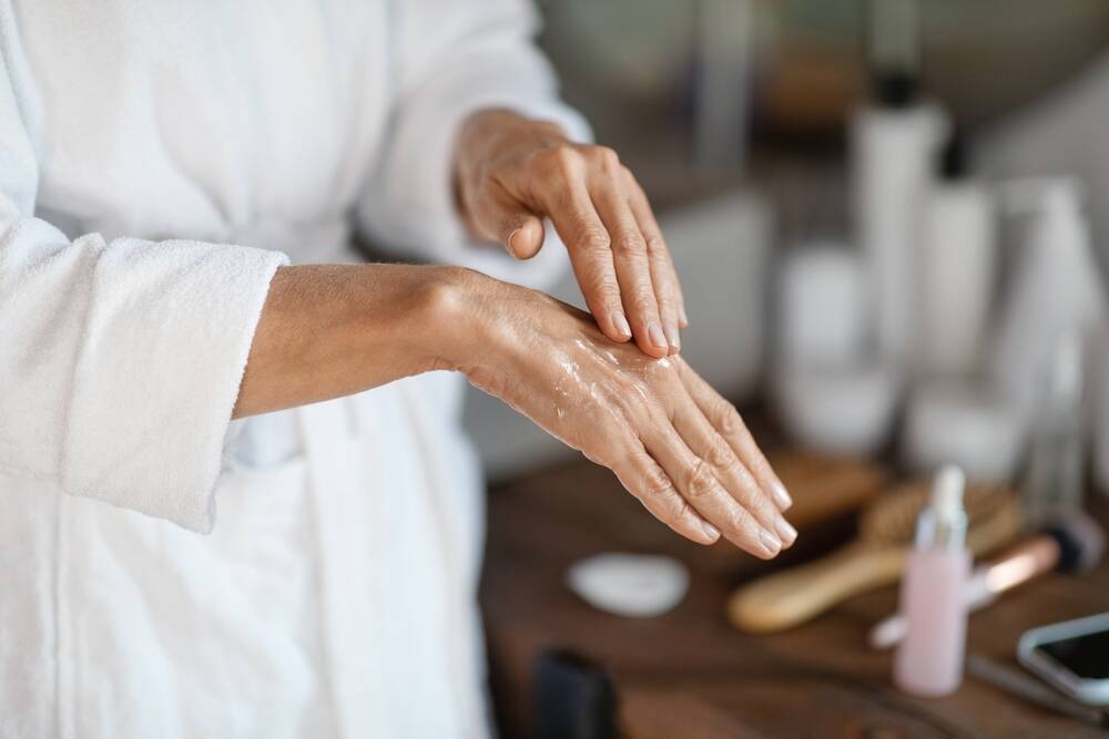 senior woman using moisturizer